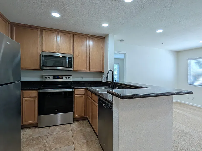 Kitchen with granite counter top, refrigerator, microwave, electric range & oven, and dishwasher