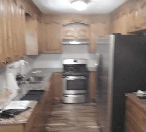 DESIGNER KITCHEN WITH APPLIANCES AND CEILING FAN LIGHT.