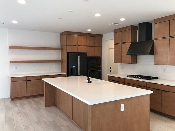 Modern mid century style chefs kitchen. Behind the stove wall is a large walk through pantry.
