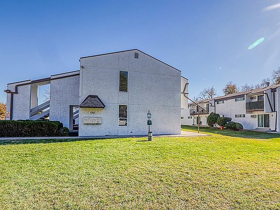 Charming apartment building with modern architecture, nestled in a serene neighborhood with lush green lawns.