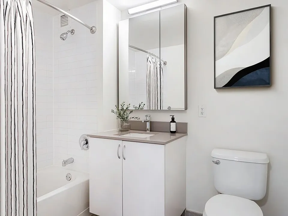 Renovated Package I bath with white cabinetry, grey quartz countertops, and hard surface flooring