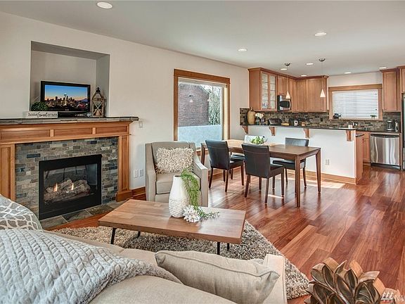 Gorgeous living room with natural light, cozy gas fireplace, hardwoods & balcony.