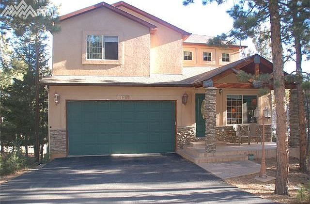 Front of home with front porch to sit and enjoy the quiet woods