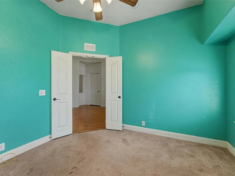 Downstairs office with carpet and a ceiling fan