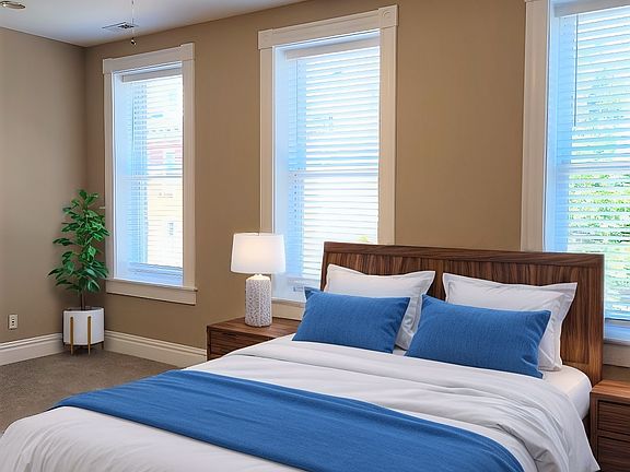 Spacious primary suite with large windows (virtual staged)