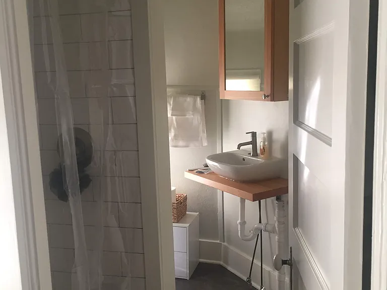 shower on left with sink and medicine cabinet beyond. In floor heat in bathroom