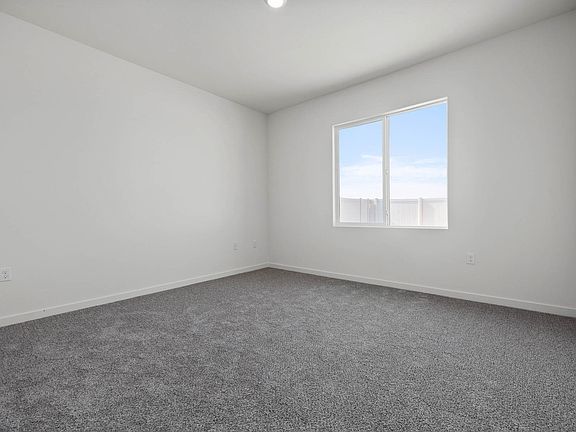 The master bedroom is spacious and has a large window.