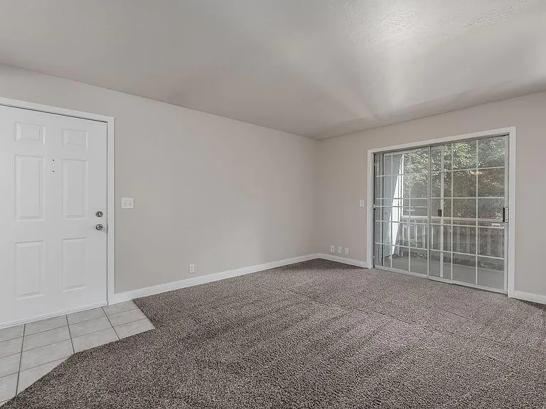 View of living room with the front door and balcony door.