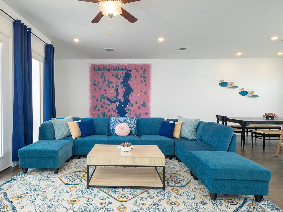 Spacious living room with vibrant pops of color, a large L-shaped couch, cozy fireplace, and TV_perfect for lounging and unwinding.