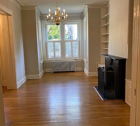 living room has beautiful chandelier and built-in bookshelves around the fireplace.