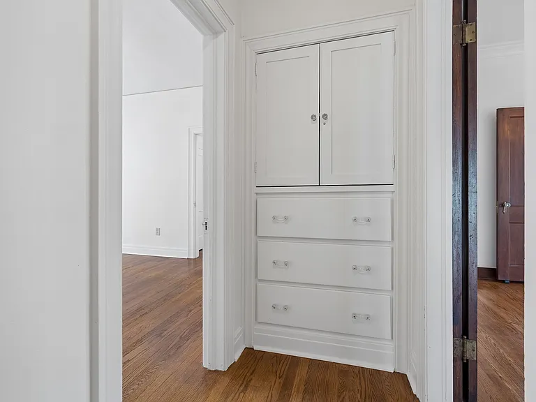 Hallway storage. Door on left goes to bedroom 2. Door on right connects to formal dining room