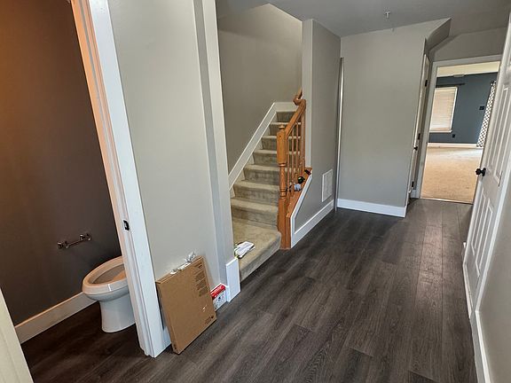Foyer with half bath looking into large basement recreation room. Includes a hallway closet on the left and garage access on the right.