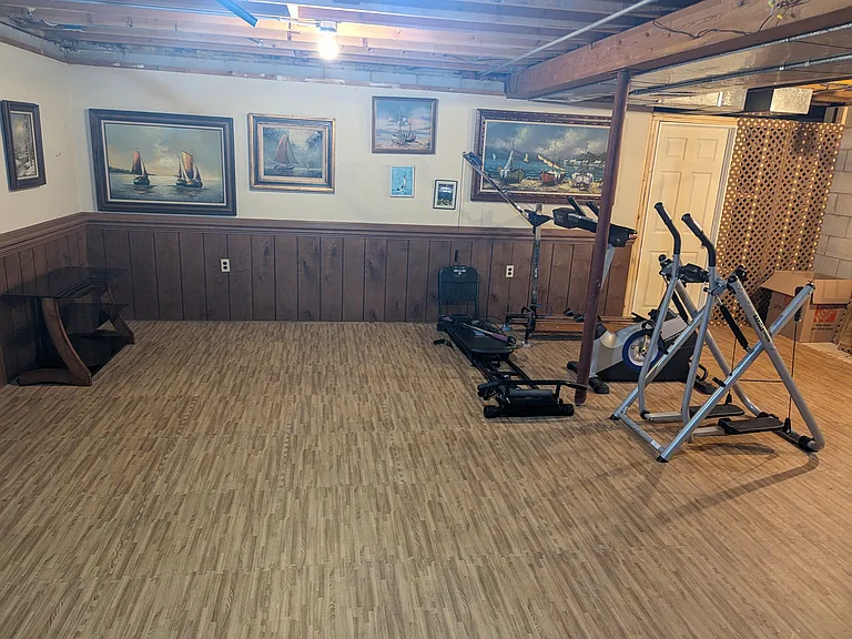 Basement workout room with soft floor tiles and laundry room