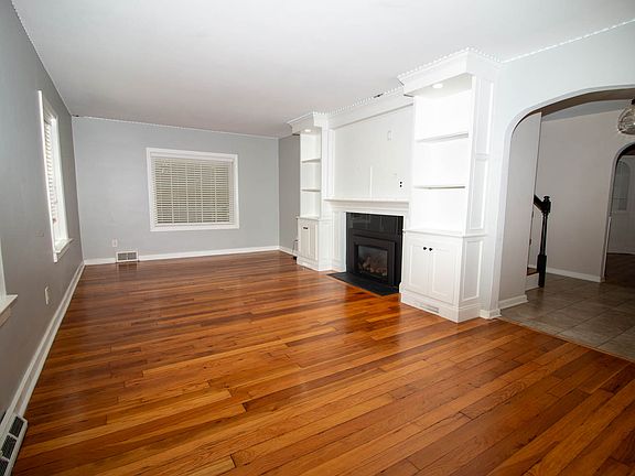 Living room with fireplace and built in bookcase that flank you big screen TV
