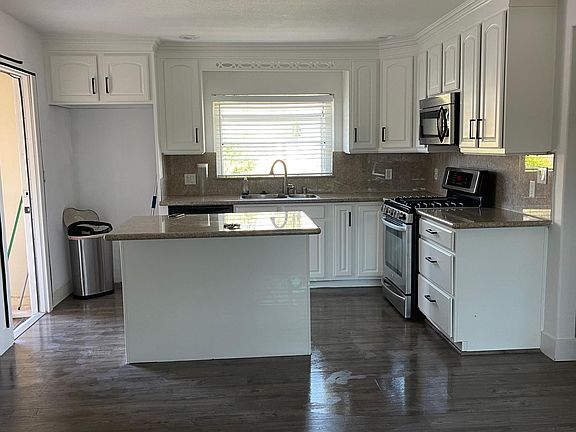 Kitchen equipped with stove and over the range microwave and dishwasher. Beautiful granite stone throughout.