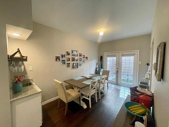 large dining room with wet bar, and french doors leading to back patio