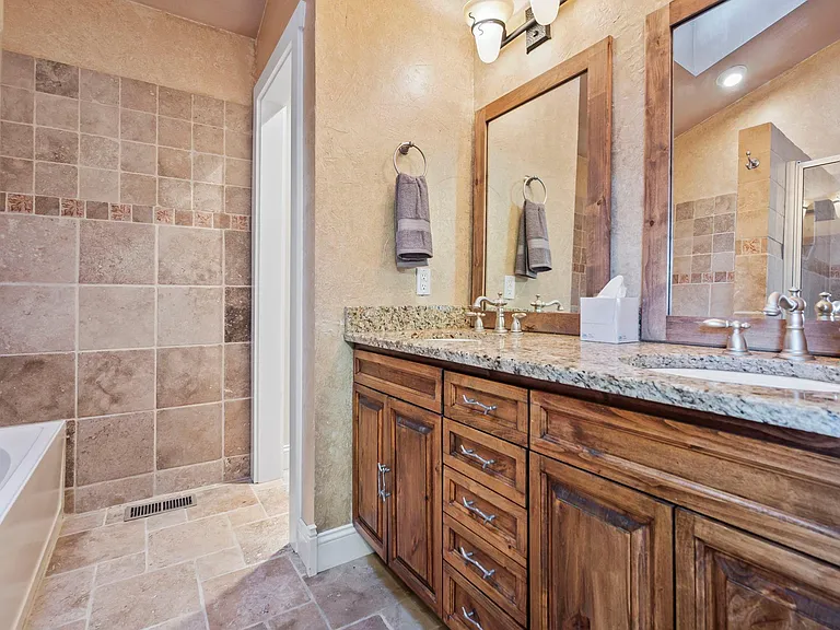 Feeling at home is easy with the 5-piece primary bathroom suite finished with custom cabinetry and granite countertops.
