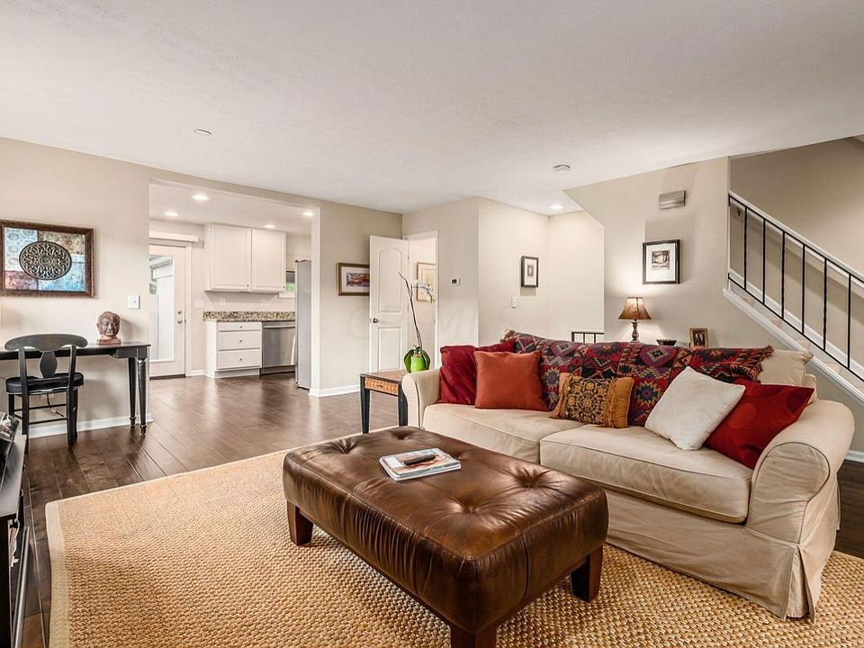 Spacious living room with bright windows, open to dining and kitchen areas