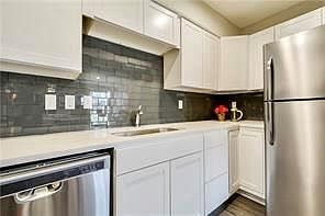 SS appliances in the kitchen with subway tile backsplash.