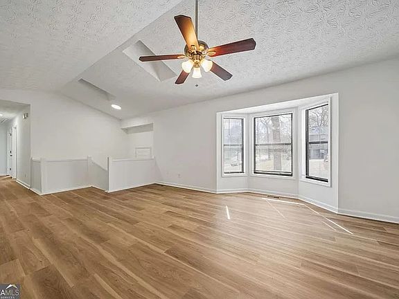 Spacious and open family room with dramatic fireplace and vaulted ceiling.