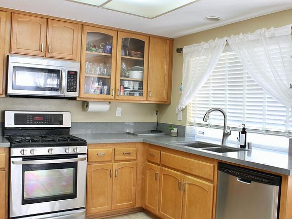 Kitchen with quartz countertop. Stainless steel appliances: LG gas cooking range, LG microwave, Dishwasher, and LG refrigerator (not visible)