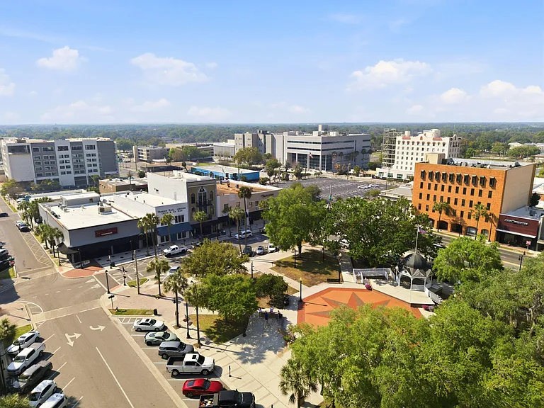 Aerial view of a walkable downtown district with nearby offices, shops, and green space for easy everyday access.