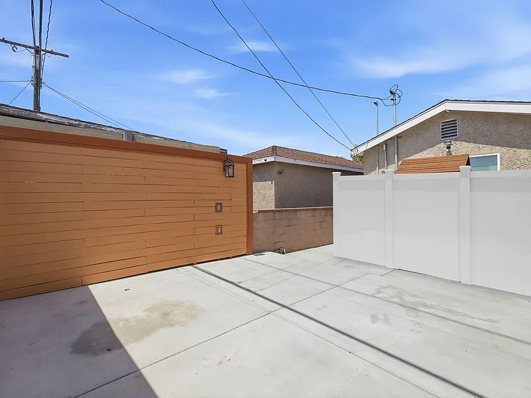 *DIGITALLY ALTERED PHOTO*- This photo shows the white Vinyl fence that will be installed to create seperation from front house