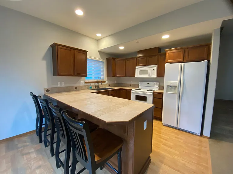 Kitchen, featuring an updated farm style sink and ample cupboard space, and spacious bar seating.