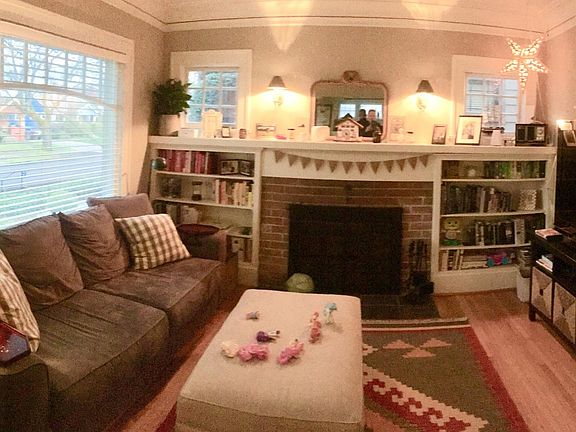Living room with wood burning fireplace and built-in shelves