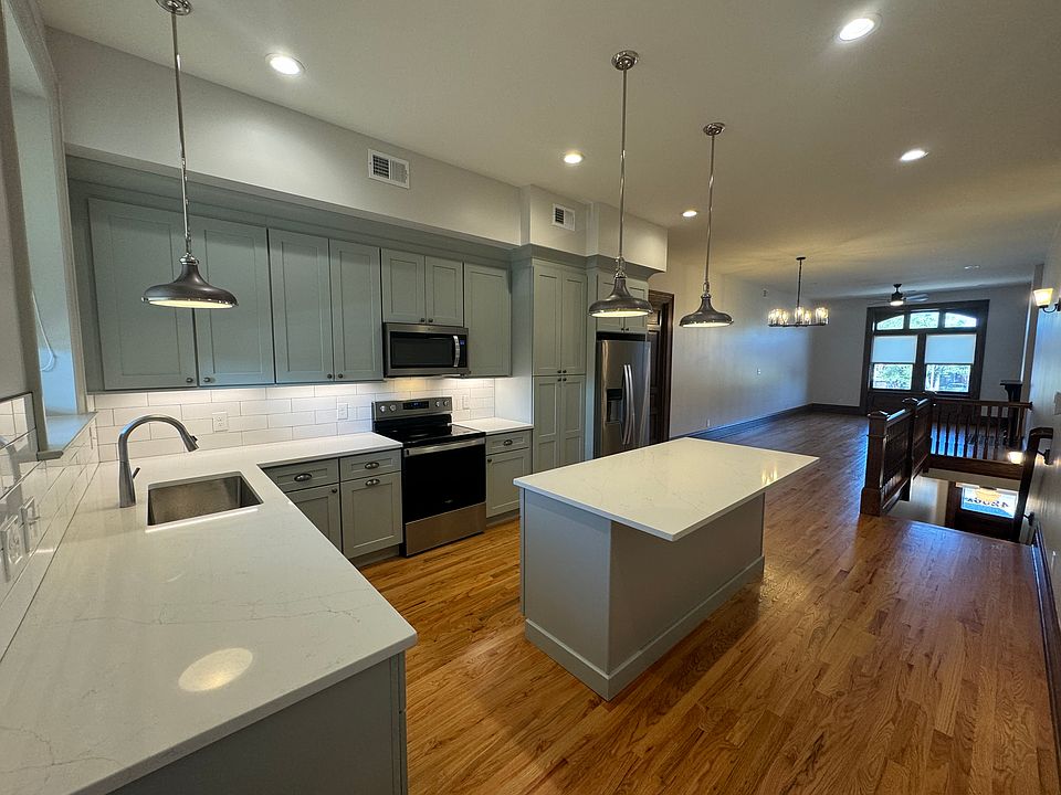 Enter the kitchen from the back entry. Large island, quartz countertops, subway backsplash, all new cabinetry