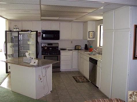 Stainless steel side by side refrigerator, stove, microwave and in the open kitchen.