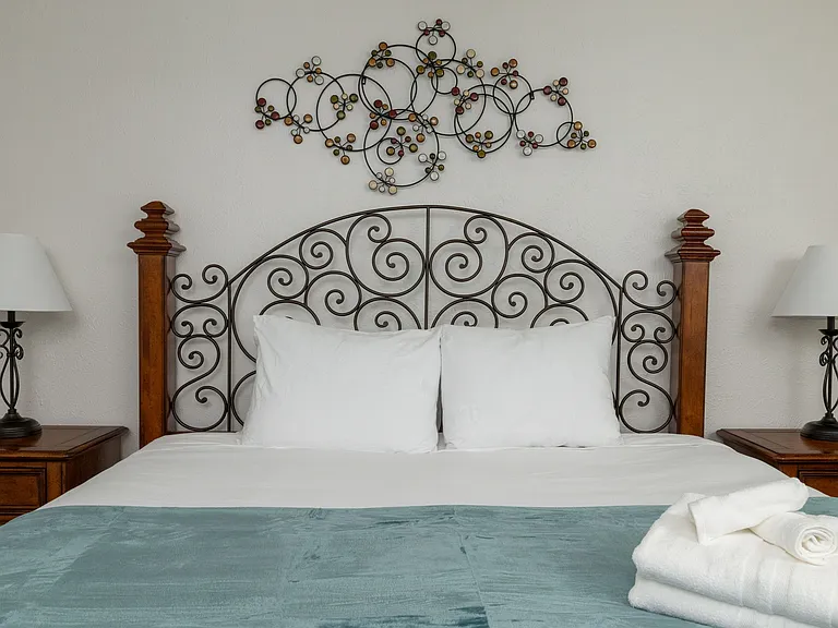 Relax in the primary bedroom featuring a luxurious king-size bed, full-body mirror, flat-screen Roku TV and an attached bathroom for your convenience. Don't forget the luggage carrier and hangers in the large, walk-in closet!
