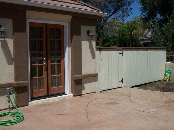 The wood fence to the right of the home has been replaced with vinyl fencing