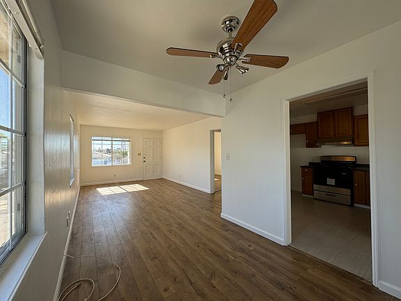 View from dining area. Entry into kitchen visible at right. Brand new ceiling fan installed, perfect location for potential dining table.