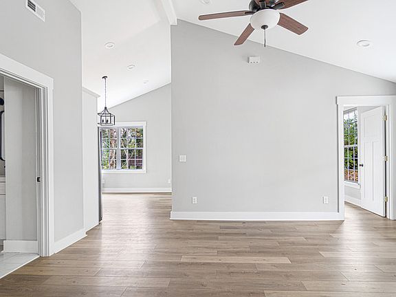 The living room, showing one full bath on the left, the entryway into the kitchen in the middle, and a bedroom on the right