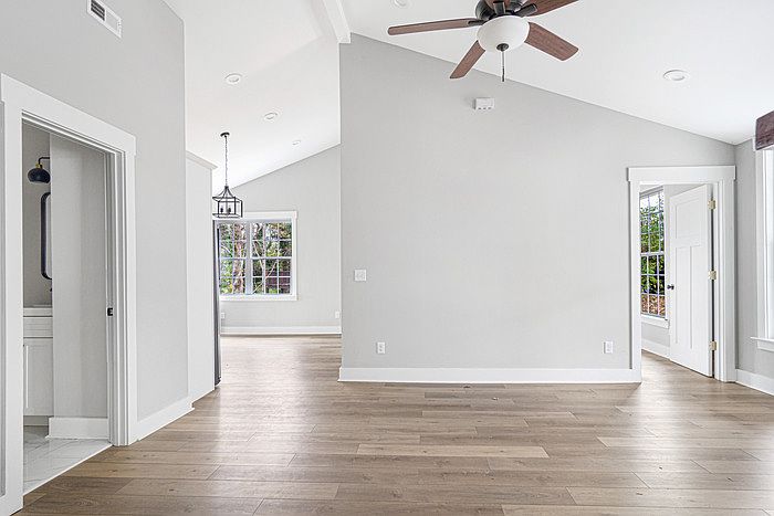 The living room, showing one full bath on the left, the entryway into the kitchen in the middle, and a bedroom on the right