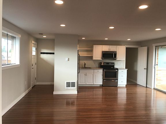 Front door/entrance, kitchen and living. There is an island in the kitchen (not shown)