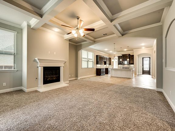 The great room feature fire place and coffered ceiling