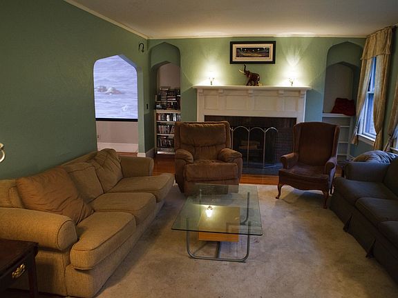 Living room facing decorative fireplace and entrance to dini