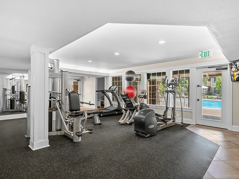 Fully equipped fitness center with modern machines and natural light.