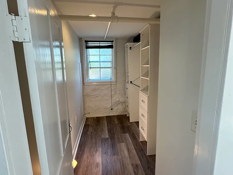 Small home office or walk in closet with storage wall unit.