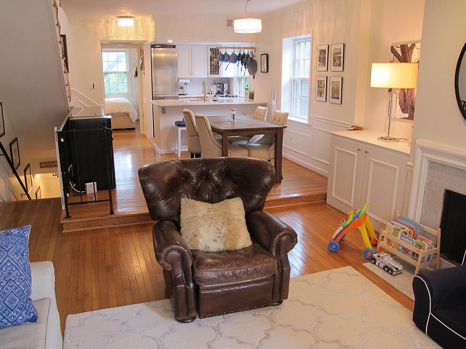 A photo of the dining area and kitchen taken from the living room. The stairs on the left go to the exit of the apartment. The first bedroom is at the end.