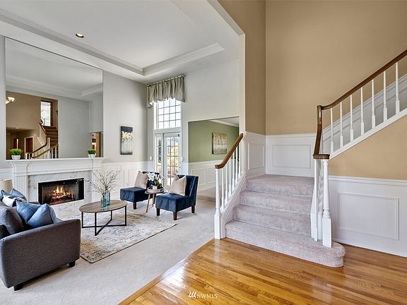 Here's another view of the room featuring a tray ceiling and wainscotting. The formal dining room with an incredible lake view is adjacent.