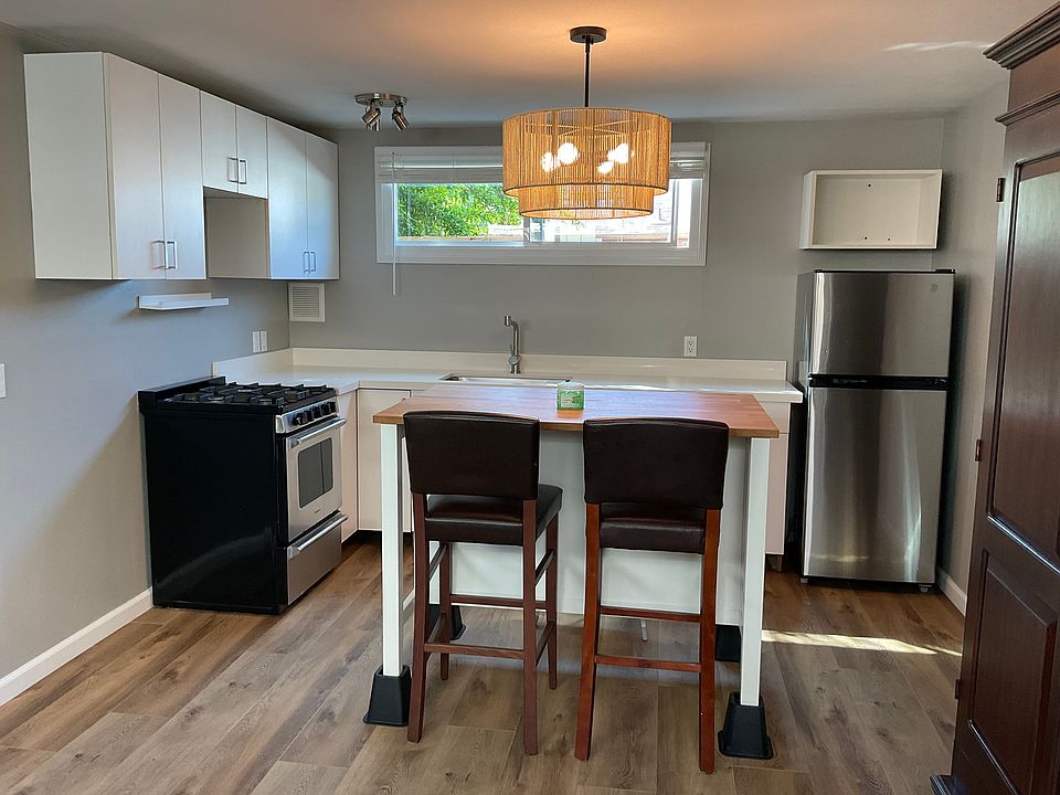 Kitchen with center island, stainless steel appliances, and quartz countertops.