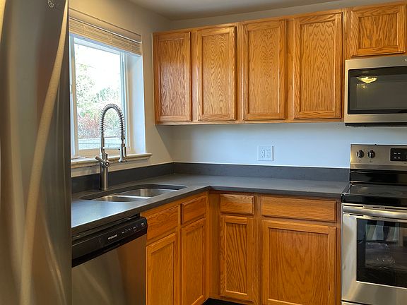 kitchen is updated with new stainless appliances, stone countertops and new tile floor