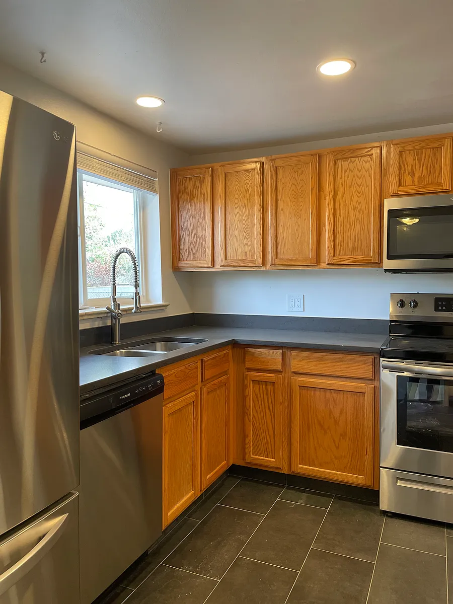 kitchen is updated with new stainless appliances, stone countertops and new tile floor - 670 Cody St
