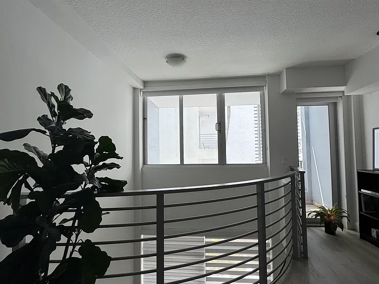 Bedroom - Spacious loft-style bedroom with high ceilings and an open layout, offering plenty of room for a king-size bed, seating area, or home office setup. Blackout shades for ultimate privacy and glare resistance.