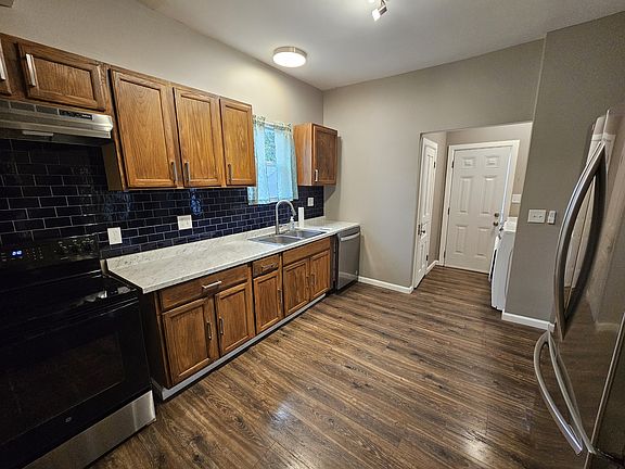 Kitchen with laundry area, half bath, and exit to fully privacy fenced back yard