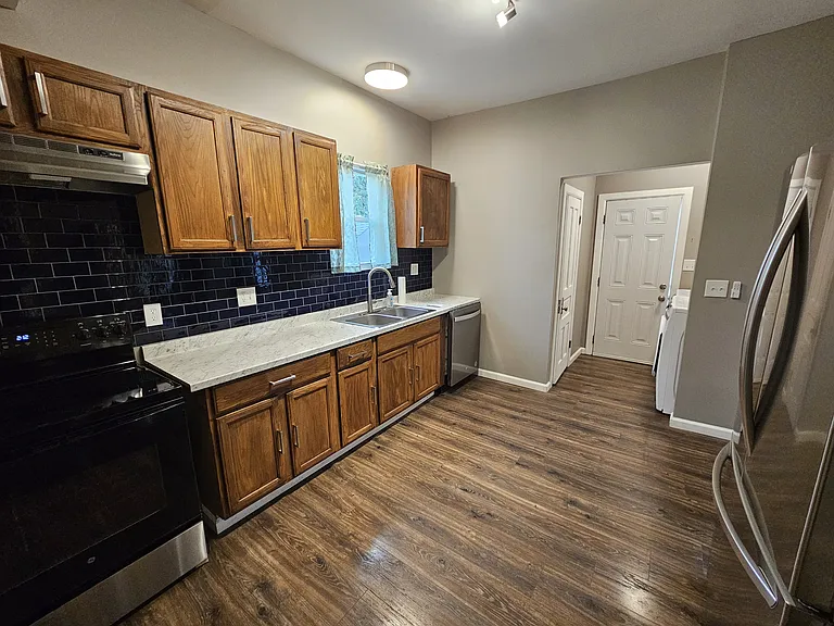 Kitchen with laundry area, half bath, and exit to fully privacy fenced back yard