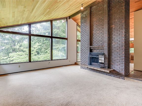 Huge living room with vaulted ceilings and wide open windows.
